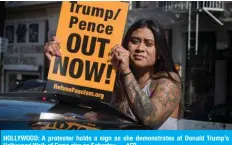  ?? — AFP ?? HOLLYWOOD: A protester holds a sign as she demonstrat­es at Donald Trump’s Hollywood Walk of Fame star on Saturday.