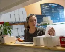  ?? Emily Matthews/Post-Gazette ?? Ciara Teliski, an employee at Mi Empanada, checks a receipt for a takeout order at the Lawrencevi­lle restaurant.