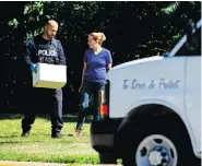  ?? GEOFF ROBINS / AFP / GETTY IMAGES ?? In a ravine behind a home on Mallory Crescent in Toronto, a police officer carries human remains believed to be in connection to alleged serial killer Bruce McArthur.