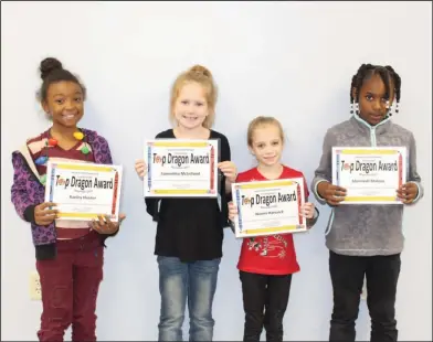  ?? Brittany Williams/News-Times ?? Top Dragons: Junction City Elementary students Kaeley Hunter, Samantha McLelland, Naomi Hancock and Khennedi Malone were recongized with Top Dragon awards during a school board meeting.