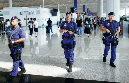  ?? THOMAS PETER / REUTERS ?? Armed police patrol the departure hall of Hong Kong Internatio­nal Airport on Wednesday after the city’s High Court issued an interim injunction banning unlawful obstructio­n of airport operations.