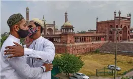  ?? — PTI ?? Two men greet each other on the occasion of Id-ul-Fitr, marking the end of the Muslim fasting month of Ramzan, near a virtually deserted Jama Masjid during the ongoing Covid-19 lockdown in Delhi on Friday.