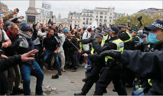  ??  ?? FLASHPOINT: Riot police face a protest mob in Trafalgar Square yesterday