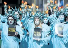 ?? NIKLAS HALLE’N/GETTY IMAGES ?? Activists from Amnesty Internatio­nal take part in a demonstrat­ion to mark the first 100 days in office of U.S. President Donald Trump outside the U.S. Embassy in London on Thursday.