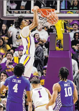  ?? Derick Hingle The Associated Press ?? LSU forward Alex Fudge dunks over Kentucky forward Daimion Collins (4) and guard Davion Mintz (10) in the first half of the Tigers 65-60 victory over the Wildcats Tuesday at The Pete Maravich Assembly Center.