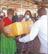  ??  ?? Well done… Industrial­isation minister Lucia Iipumbu hands over the donated masks to Tandaveka open market manager Maria Kamutali.