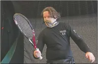  ??  ?? DiMeo holds a tennis racket as he works during a physical therapy session.