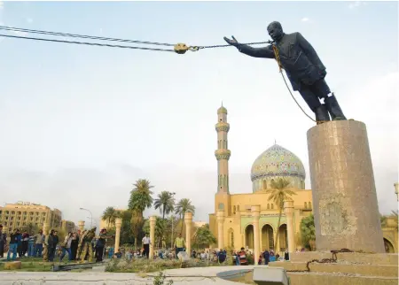  ?? GILLES BASSIGNAC/GAMMA-RAPHO VIA GETTY ?? U.S. troops topple a statue of Saddam Hussein on April 9, 2003 in Baghdad, Iraq.