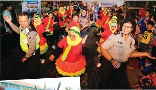  ?? GALIH COKRO/JAWA POS ?? SEMARAK: Polisi ikut menari bersama warga Demak Jaya Gang 10, RT 14, RW 10, peserta lomba yel-yel Kamis malam (16/3). Foto bawah, siswa SMAN 12 bercengker­ama dengan robot Yamaha N-Max di sela-sela sosialisas­i tertib berlalu lintas kemarin (17/3).