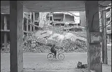  ?? AFP ?? A man rides past destroyed buildings in the rebelheld town of Douma, on the eastern outskirts of Damascus, on Saturday.