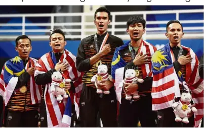  ??  ?? We did it!: Malaysian sepak takraw players singing along as “Negaraku” is being played after they won the men’s regu gold beating Indonesia yesterday. — Reuters