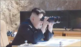  ?? KRT via AP Video ?? This image made from video of a news bulletin aired by North Korea’s KRT on Tuesday shows what was said to be North Korea leader Kim Jung Un, center, using binoculars to watch the launch of a Hwasong-14 interconti­nental ballistic missile, ICBM, in...