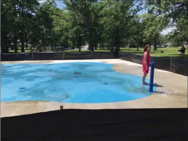  ?? RICHARD PAYERCHIN — THE MORNING JOURNAL ?? Linda O’Connor, administra­tive assistant at Lorain’s Public Property Department, stands barefoot to feel the surface of Lorain’s new splash pad at Central Park, 2800 Oakdale Ave., on June 16. The city has scheduled a grand opening for the pad June 21.