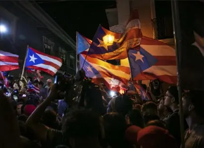  ?? Ilana Panich-Linsman/The New York Times ?? People react to the resignatio­n of Puerto Rico Gov. Ricardo Rossello in San Juan, Puerto Rico, in July 2019.