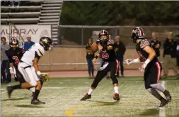  ?? Nikolas Samuels /The Signal ?? Hart quarterbac­k JT Shrout throws a shovel pass to running back Ben Rosen against the Golden Valley Grizzlies at Valencia on Oct. 27.