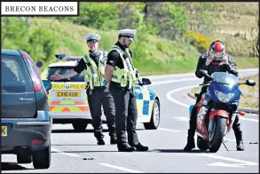  ??  ?? BRECON BEACONS
Left, police stop motorists near Nant Ddu, Wales. Above, a paddle boarder and her dog in the sea off Charmouth. Right, children in Dovedale. Below, painting a beach hut in Walton-on-the-naze, Essex