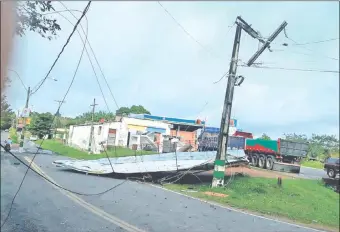  ??  ?? Una columna partida en un extremo, cables del tendido eléctrico sueltos y chapas de zinc tiradas a la ruta por efecto de los fuertes vientos tipo tornado en Ypacaraí.