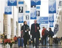  ?? STACEY WESCOTT/CHICAGO TRIBUNE ?? Shayna Stahl and Cody Birdwell, band directors from the University of Kentucky, stroll down the corridor en route to The Midwest Clinic at McCormick Place West on Dec. 21.