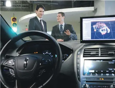  ?? SEAN KILPATRICK / THE CANADIAN PRESS FILES ?? Blackberry QNX director of engineerin­g Sheridan Ethier speaks to Prime Minister Justin Trudeau on a tour of a company facility last year. The federal budget bets heavily on facilitati­ng innovation by high-tech companies.