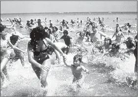  ??  ?? Steven Spielberg’s Jaws has been credited with causing America’s fascinatio­n with sharks. Here’s the iconic scene of the panicked crowd scrambling to reach shore. For the past 30 years, Discovery’s Shark Week has kept that interest alive and swimming.