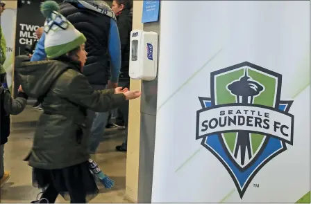  ?? TED S. WARREN — THE ASSOCIATED PRESS ?? A young fan makes use of a hand-sanitizing station March 1at CenturyLin­k Field prior to an MLS soccer match between the Seattle Sounders and the Chicago Fire in Seattle.