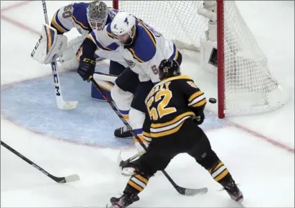  ?? The Associated Press ?? Boston Bruins forward Sean Kuraly scores against St. Louis Blues goaltender Jordan Binnington and Joel Edmundson during Game 1 of the NHL Stanley Cup final, Monday, in Boston. Boston won 4-2.