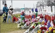  ?? ERIC GAY / ASSOCIATED PRESS ?? Christina Osborn and her children, Alexander Osborn and Bella Araiza, visit a makeshift memorial for the shooting victims Sunday at First Baptist Church in Sutherland Springs, Texas.