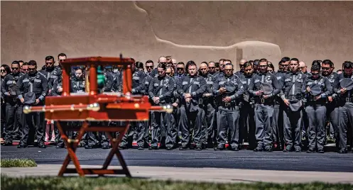  ?? PHOTOS BY GABRIELA CAMPOS/THE NEW MEXICAN ?? New Mexico State Police officers stand together during a moment of silence while they look toward the urn containing Officer Justin Hare’s remains during Hare’s funeral services at Legacy Church in Albuquerqu­e on Wednesday.