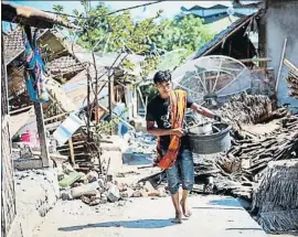  ?? STR / EFE ?? Un joven recupera unos pocos objetos de su casa destruida en Lombok