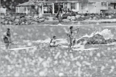  ?? SARAH GORDON/THE DAY ?? A group of kayakers and paddleboar­ders move through a rough surf in Long Island Sound on Thursday as waves crash on the shores of UConn Avery Point in Groton.