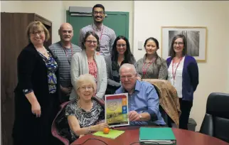  ??  ?? Sandra Schmidt, far left, with the Path to Home team present Ron and Marion Whiting with their passport home.