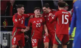  ?? Photograph: Geoff Caddick/AFP/Getty Images ?? Daniel James (centre) is congratula­ted by teammates after scoring Wales’ fourth goal in the 86th minute.