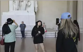  ?? BANI SAPRA — ASSOCIATED PRESS ?? Visitors sporting bucket hats and Washington D.C. merchandis­e pose for photos at the Lincoln Memorial in Washington. An enlarged Chinese middle class has become an increasing­ly lucrative market for the U.S. travel industry.