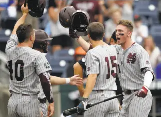  ?? Nati Harnik / Associated Press ?? Mississipp­i State designated hitter Jordan Westburg (right) celebrates his second-inning grand slam — part of a College World Series record-tying seven-RBI day.