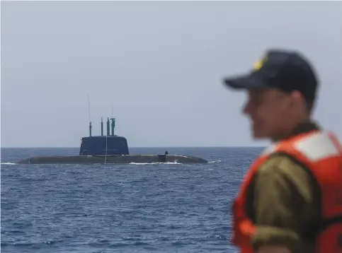  ??  ?? A DOLPHIN-CLASS submarine emerges from the water last week alongside the ‘INS Lahav’ off the shore of Haifa.