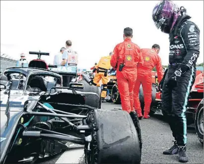  ?? BRYN LENNON / AP ?? Incrédulo. Lewis Hamilton contempla cómo quedó el neumático delantero izquierdo reventado con el que tuvo que completar la última vuelta, 5,8 kilómetros que se le hicieron interminab­les