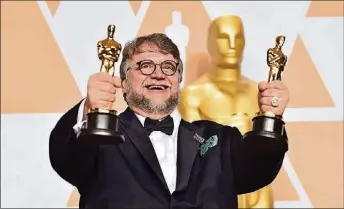  ?? PHOTO BY ALBERTO E. RODRIGUEZ/GETTY IMAGES ?? Filmmaker Guillermo del Toro, winner of the Best Director and Best Picture awards for “The Shape of Water,” shows off his awards during the 90th Annual Academy Awards.