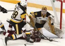  ?? CLIFFORD SKARSTEDT EXAMINER ?? Peterborou­gh Petes’ Tucker Robertson is checked to the ice by Bulldogs’ Mark Duarte and goalie Marco Costantini during Hamilton’s 7-3 win Thursday and sweep of the series.