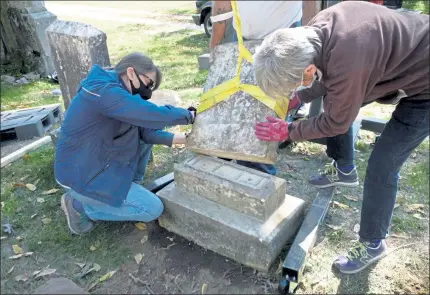  ?? M.E. JONES / LOWELL SUN ?? Cemetery Commission­er Barbara Yocum and volunteer Barbara Brockelman work on resetting one of the damage headstones in Shirley’s Center Cemetery.