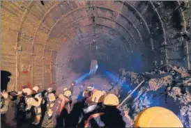  ?? AP ?? ITBP personnel use torches to gain access inside a tunnel at an NTPC power plant in Tapovan to rescue around 30 workers trapped inside on Tuesday.