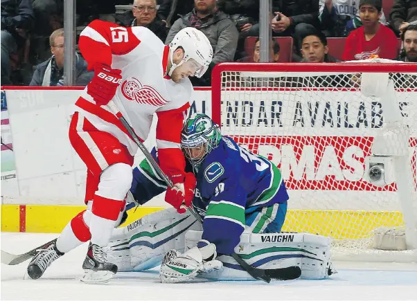  ?? JEFF VINNICK/NHLI VIA GETTY IMAGES ?? Canuck Ryan Miller thwarts Riley Sheahan of the Red Wings during Vancouver’s 4-1 win Saturday at Rogers Arena. Several family members were on hand to see Miller face brother Drew.