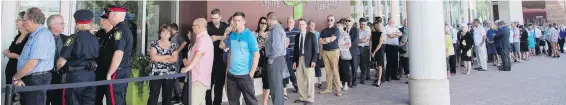  ??  ?? Mourners line up to enter the Fredericto­n Convention Centre during Thursday’s public visitation for slain city constables Sara Burns and Robb Costello.