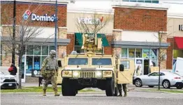  ?? JIM MONE AP ?? National Guard soldiers maintain watch at a shopping center in Brooklyn Center, Minn., Monday after the fatal police shooting Sunday of a young Black man.