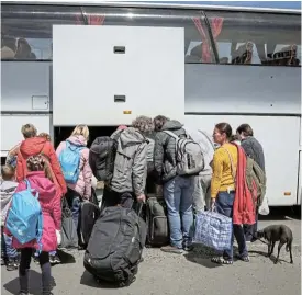  ?? /Reuters ?? Escape: Ukrainian refugees board a bus in Zaporizhzh­ia bound for Poland. With winter closing in, Ukraine’s neighbours are preparing for a surge in numbers of people fleeing the country.