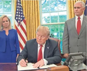  ?? PABLO MARTINEZ MONSIVAIS/AP ?? President Donald Trump, joined by Homeland Security Secretary Kirstjen Nielsen and Vice President Mike Pence in the Oval Office, signs his executive order to end family separation­s Wednesday.