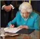  ??  ?? THE QUEEN: Signs document to record her attendance.