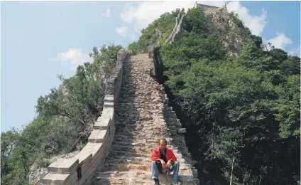  ?? Picture: Reuters ?? TAKE A BREAK. A man rests while working on the reconstruc­tion of the Great Wall in China.