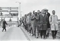  ?? Tom Lankford / Birmingham News / Alabama Department of Archives and History ?? Lewis, right, with fellow protesters at the Edmund Pettus Bridge during the 1965 march from Selma to Montgomery, Ala.