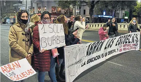  ?? FACUNDO LUQUE ?? PROTESTA. Grupos de padres reclamaron anoche en la esquina de Colón y La Cañada el fin de las burbujas y la vuelta a la presencial­idad total en los colegios cordobeses.