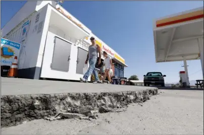  ?? The Associated Press ?? AFTERMATH: A crack is seen in a gas station’s driveway in the aftermath of an earthquake Saturday in Trona, Calif. Crews in Southern California assessed damage to cracked and burned buildings, broken roads, leaking water and gas lines and other infrastruc­ture Saturday after the largest earthquake the region has seen in nearly 20 years jolted an area from Sacramento to Las Vegas to Mexico.